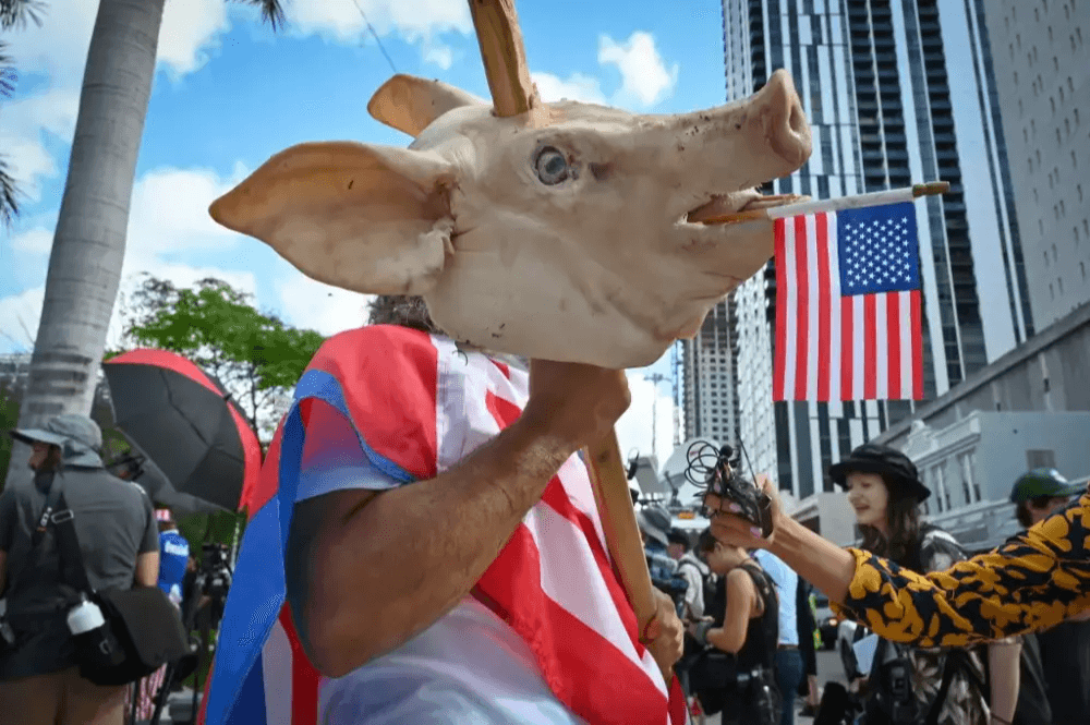 Hombre con cabeza de cerdo protesta.