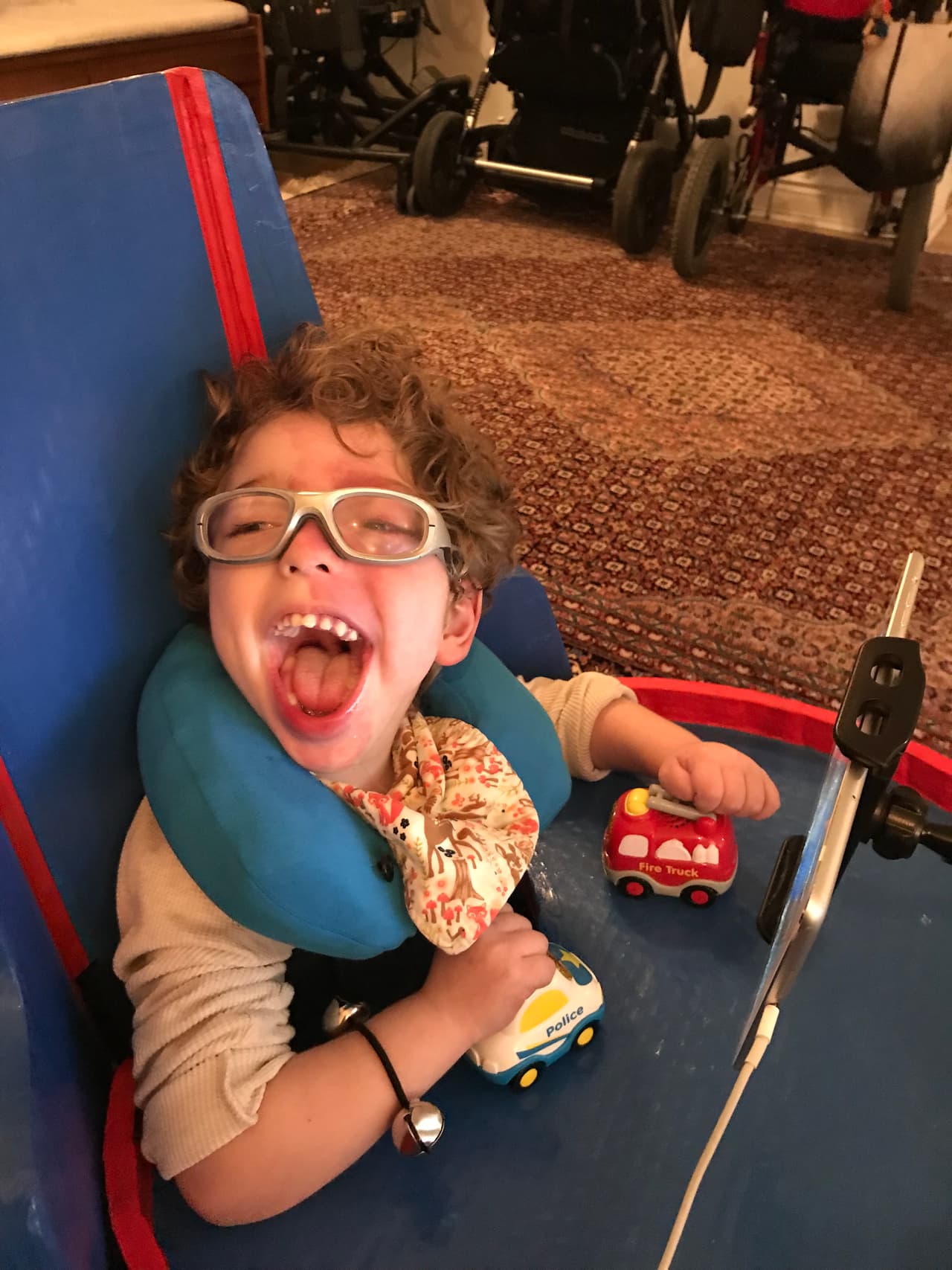 <b>Una silla a la medida. </b>En casa y la escuela, Ale requiere usar muchos equipos especiales como una silla de actividades Rifton, una silla de ruedas, un asiento de baño, un 
<i>stander</i> y un caminador, pero a él no le gusta usarlos por mucho tiempo. Con la ayuda del equipo de 
<a href="http://www.adaptivedesign.org/"><u>Adaptive Design Association</u></a>, una fundación que crea equipos para discapacitados con materiales reciclables, un grupo de estudiantes de terapia física de Columbia University y su profesora Lisa Yoon diseñaron una silla para que Ale juegue en el piso. El asiento, hecho de cartón corrugado, tiene un respaldar con cierta inclinación y una bandeja para que Ale mantenga su cabeza en alto y use sus manos para jugar, así como un soporte para las piernas para que él no se mueva hacia adelante.