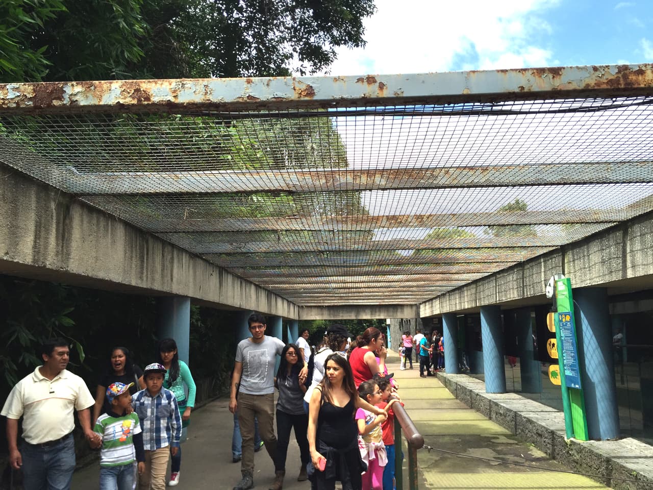 Visitantes caminan bajo estas vigas oxidadas.