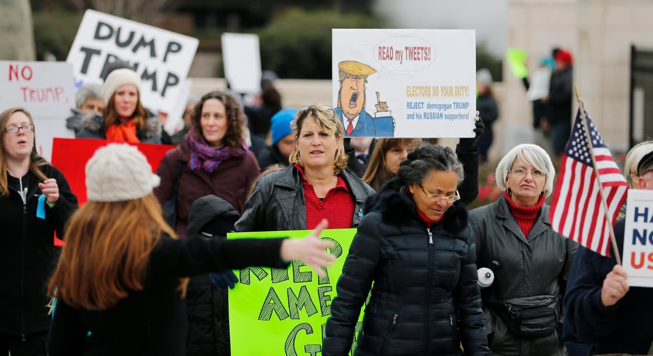Ciudadanos estadounidenses se manifiestan afuera del Capitolio Estatal de Georgia, antes del encuentro de los dieciséis electores del estado, que emitirán sus votos este 19 de diciembre de 2016. El Colegio Electoral de EE.UU se reúne este lunes para certificar la victoria del republicano Donald Trump.