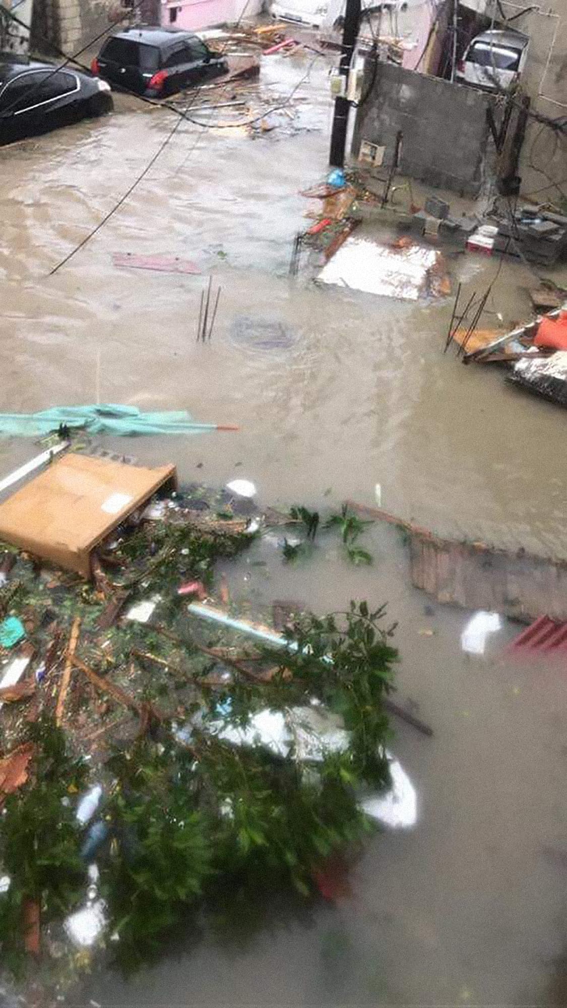 Vehículos sumergidos en una calle inundada de la isla.