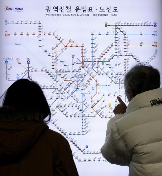 Passengers look at the Seoul metro line map at Chungmuro subway station on line 3 in Seoul on January 24, 2010. AFP PHOTO/JUNG YEON-JE (Photo credit should read JUNG YEON-JE/AFP/Getty Images)