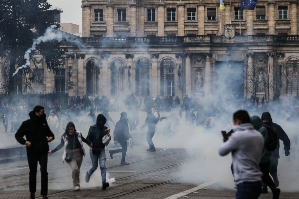 Manifestantes huyen de los gases lacrimógenos frente al ayuntamiento de Burdeos, al suroeste de Francia, este sábado 18 de marzo.