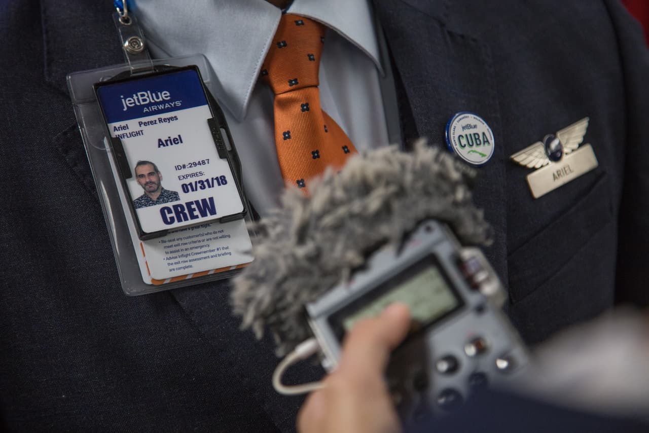 Una periodista de radio entrevista a Ariel Pérez, jefe de cabina del vuelo de JetBlue a Santa Clara, Cuba. La emoción entre los integrantes de la tripulación fue evidente durante todo el trayecto.