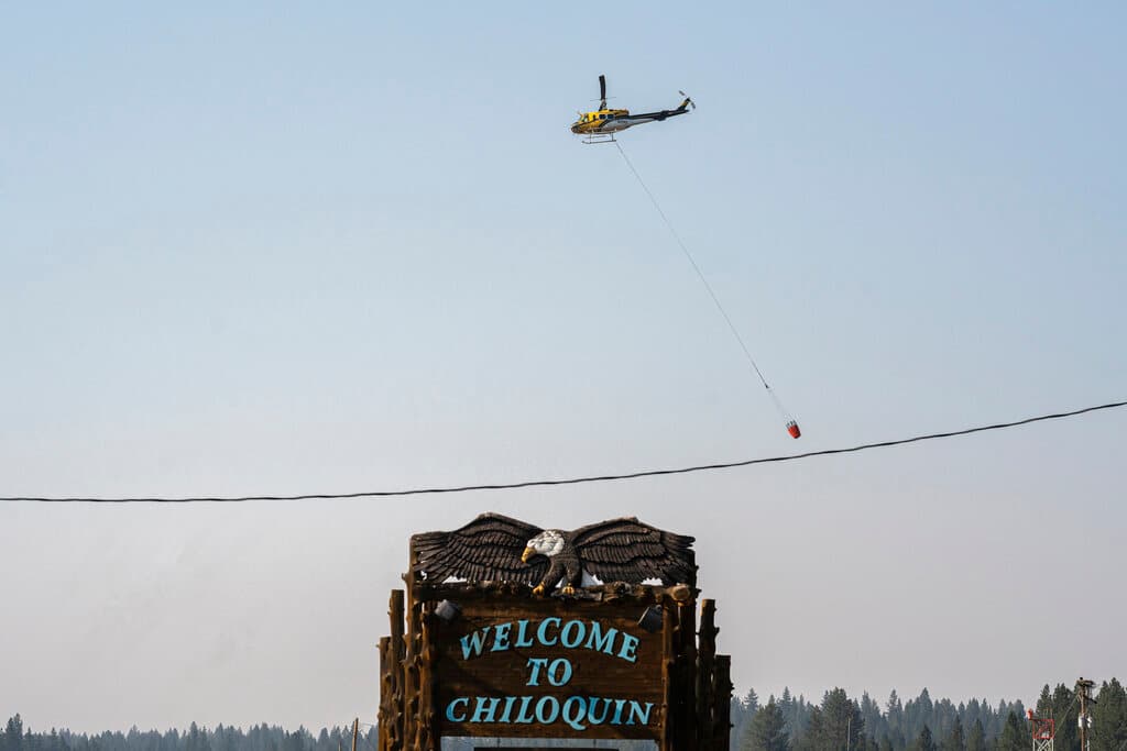 Un helicóptero transporta agua para combatir el incendio Bootleg, en Chiloquin, Oregon. Este fuego ha quemado más de 62,000 hectáreas en la zona del Bosque Nacional de Fremont-Winema y amenaza por su proximidad una línea de transmisión eléctrica de alto voltaje que conecta las redes de California y Oregon.