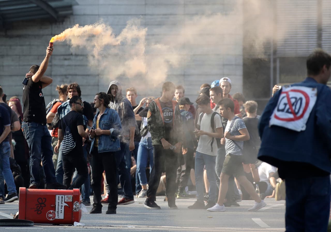 A demonstrator lights a smoke marker when blocking a street on the first day of the G-20 summit in Hamburg, northern Germany, Friday, July 7, 2017. The leaders of the group of 20 meet July 7 and 8. (AP Photo/Matthias Schrader)