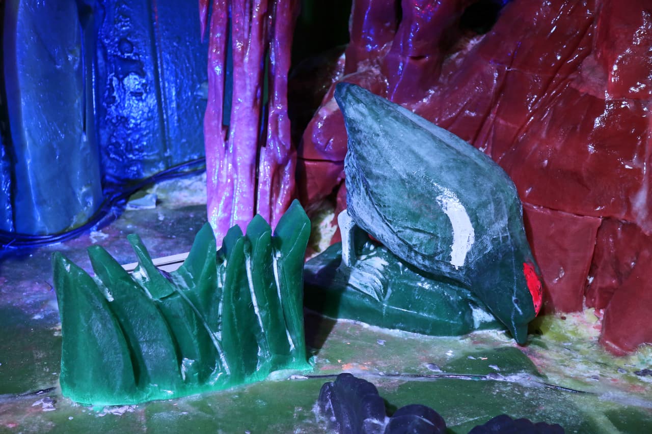 Aves exóticas en sus hábitats, todo esculpido en hielo.