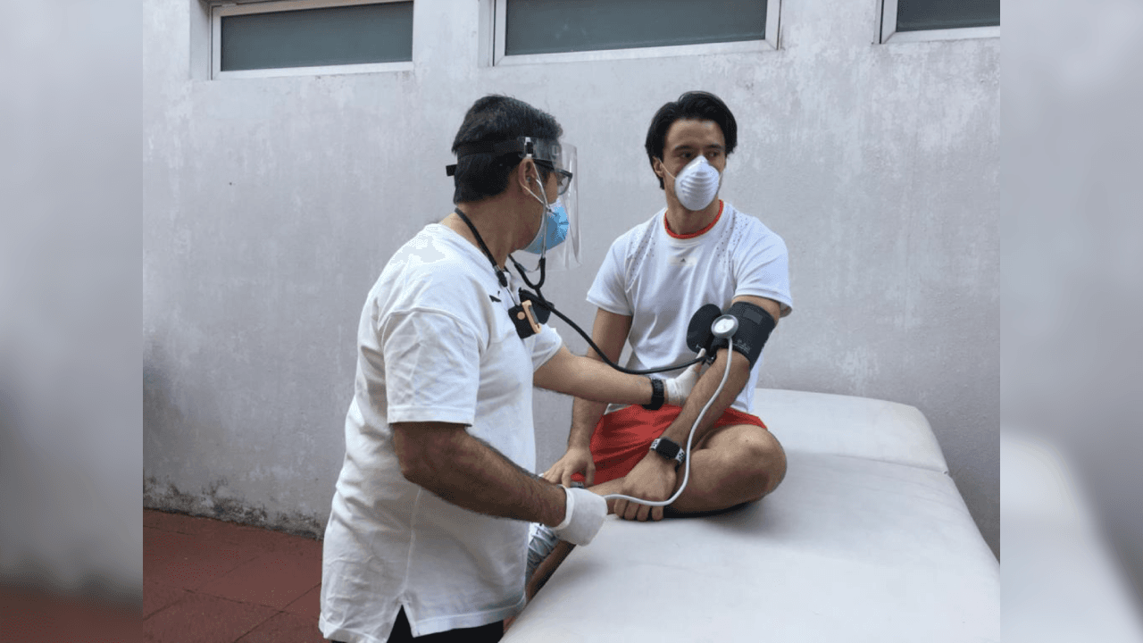 El guardameta del equipo rojiblanco al momento de tomar su pulso y temperatura.