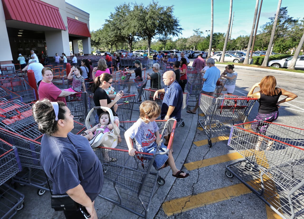 Una multitud de compradores hacen fila para hacer compras de último minuto en una tienda Costco, en Altamonte Springs, Florida.