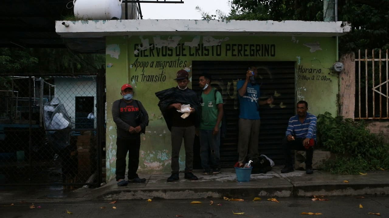 Un grupo de migrantes se resguarda de la lluvia en Tierra Blanca esperando la hora de salida del tren hacia el norte del país.
