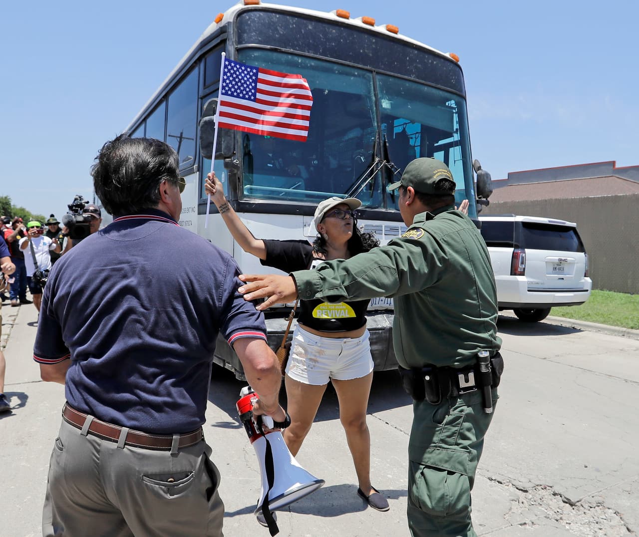 Los activistas Martha Mercado y Domingo García, de la Liga de Ciudadanos Latinoamericanos Unidos, intentan bloquear un autobús con niños inmigrantes que sale del centro de procesamiento de la Patrulla Fronteriza en McCallen, tres días después de la orden ejecutiva. 23 de junio de 2018.