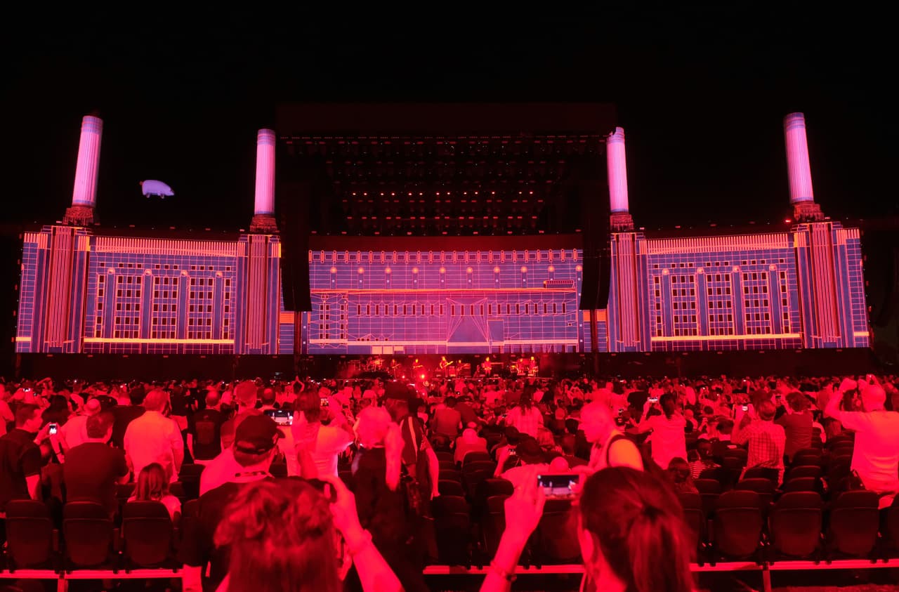 Sirenas y alarmas anunciaron la aparición de cuatro chimeneas para convertir el escenario en la portada del disco "Animals" (1977), poco antes de que Trump se convirtiera en el blanco de la diana de Waters.