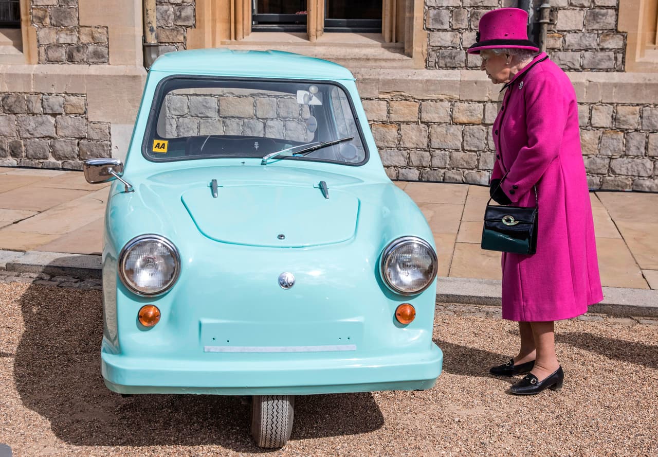 La reina Isabel II observa un pequeño vehículo de tres ruedas especial para inválidos distribuido por Motability, un esquema gubernamental para distribuir vehículos a personas con problemas de movilidad. La reina ha sido la patrocinadora principal del esquema desde su fundación en 1977.