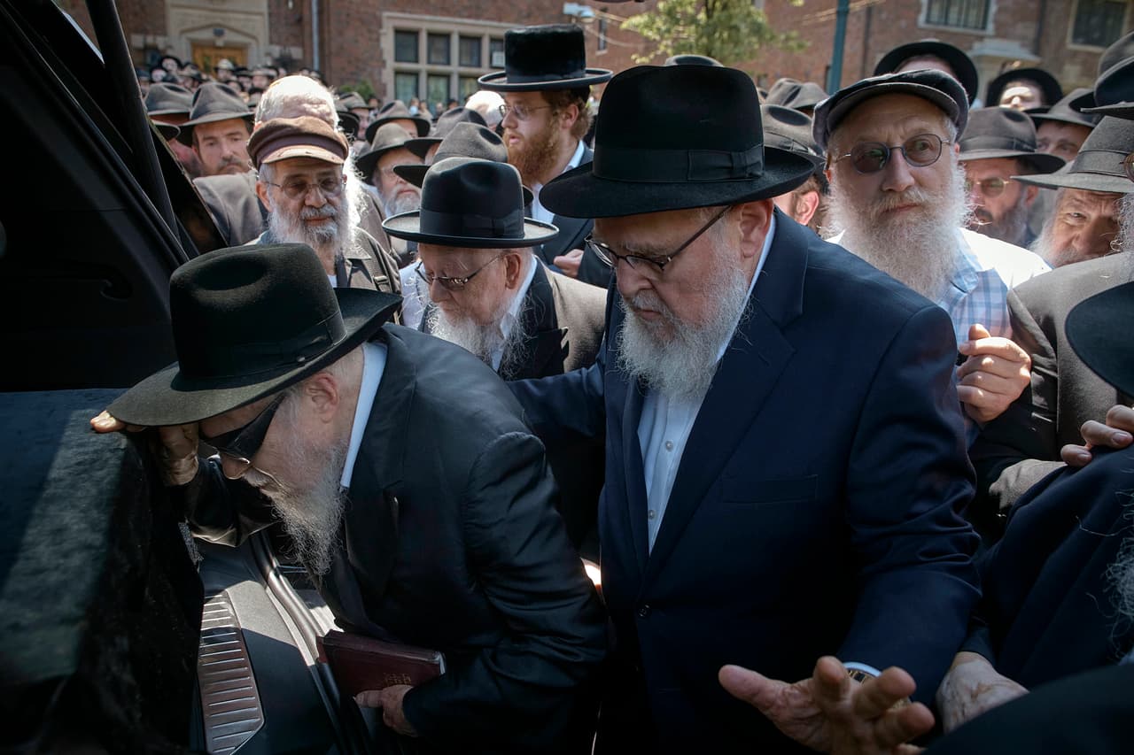 La gente toca el ataúd durante la procesión fúnebre del rabino Moshe Kotlarsky, vicepresidente de Merkos L'Inyonei Chinuch —el brazo educativo del movimiento Chabad-Lubavitch— y director de la Conferencia Internacional anual de Emisarios de Chabad-Lubavitch, el miércoles 5 de junio de 2024, en el distrito de Brooklyn, Nueva York. Kotlarsky falleció el martes. Habría cumplido 75 años dentro de cuatro días. (Foto AP/Andres Kudacki)