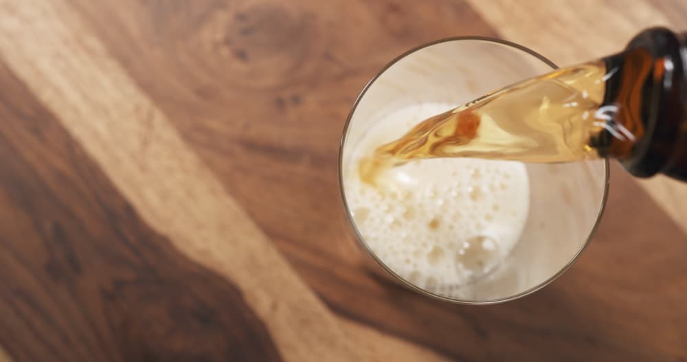 Al recipiente donde estás dejando la mezcla de rosas con miel, también ponle un poco de la cerveza a través del colador.