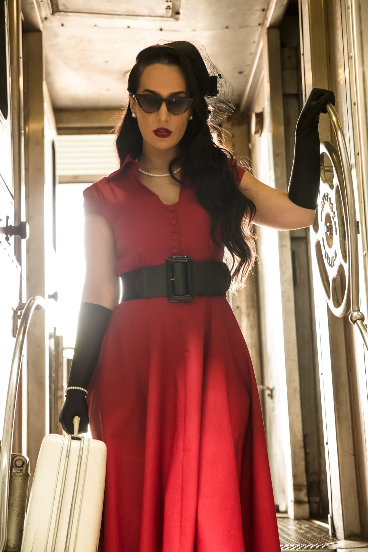 'La Mala' luce un elegante vestido rojo que evoca a las glamorosas estrellas del cine clásico.