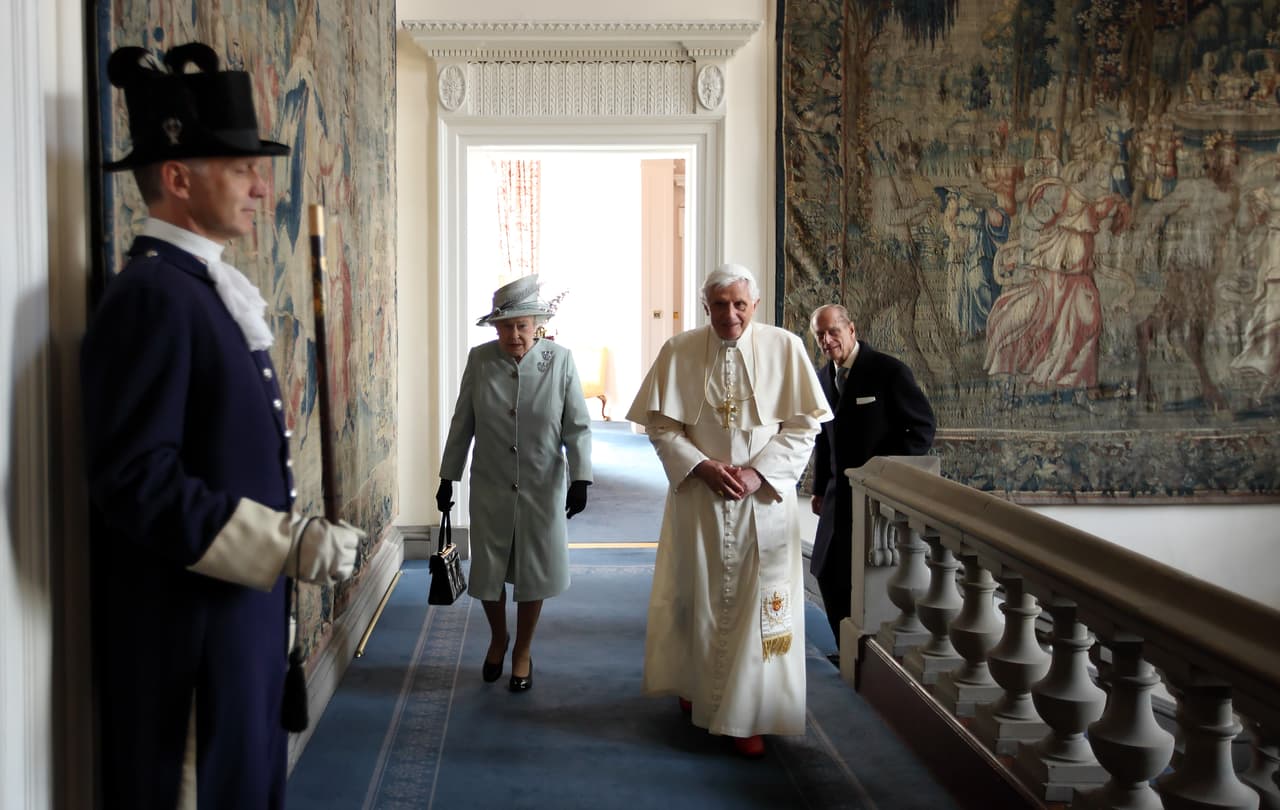 En esta fotografía del 16 de septiembre de 2010, el papa Benedicto XVI camina con la reina Isabel II y el duque de Edimburgo durante una visita al palacio de Holyroodhouse, 
<a href="https://www.univision.com/noticias/mundo/reina-isabel-feretro-cortejo-funebre" target="_blank">la residencia oficial de la monarca en Escocia</a>. Esta fue la primera visita de Estado en la historia de un Papa al Reino Unido.