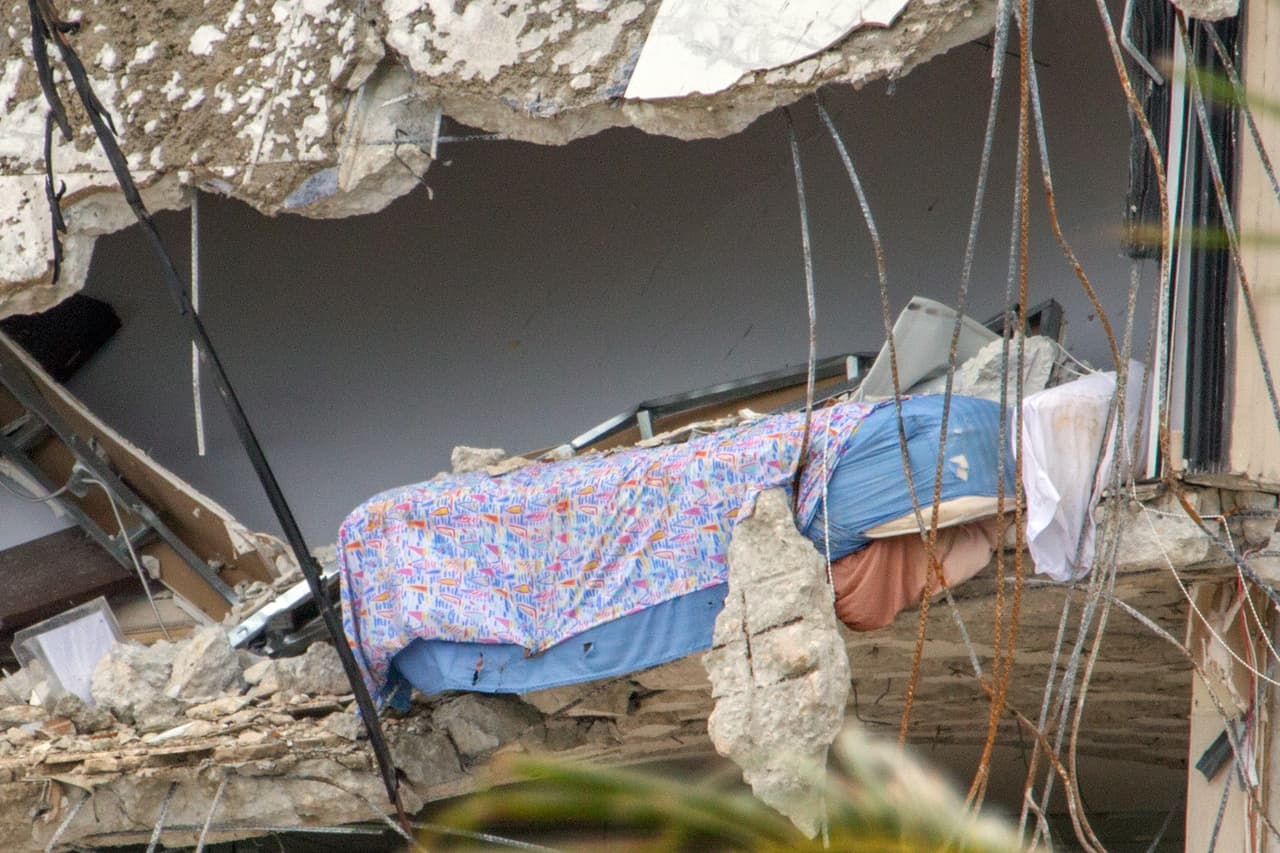 Una cama parcialmente expuesta al vacío en el borde de lo que quedó del piso siete del edificio. 
<br>
<br>Silencio absoluto. Luego del ruido estruendoso del derrumbe, ocurrido en dos etapas de unos ocho segundos de separación cerca de las 2:00 AM, es muy poco lo que interrumpe el silencio casi total en el área. 
<br>
<br>El espacio aéreo sobre la zona está suspendido y no hay ruido de sirenas de emergencia. El silencio es imprescindible para los expertos bajo la montaña de escombros, aún con la esperanza que un golpe o grito los lleve a algún sobreviviente.
<br>