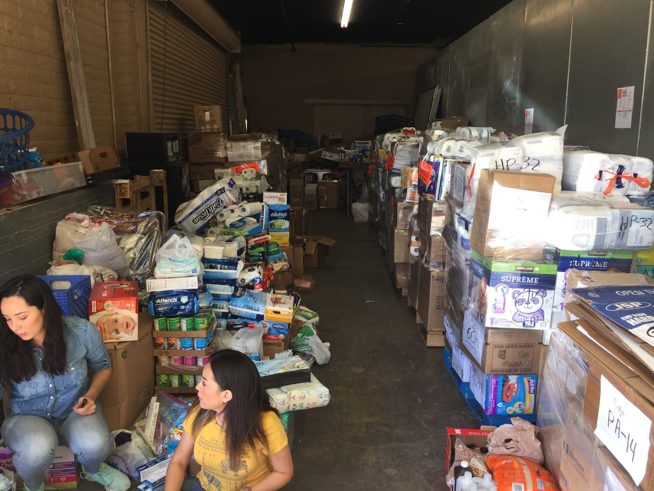 Dos voluntarias arman paquetes de la donaciones que reciben.