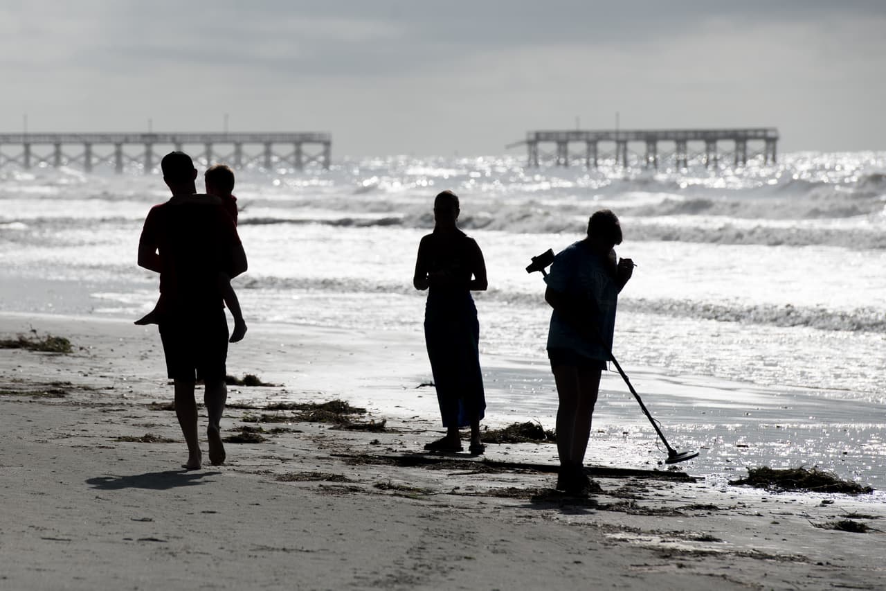 Algunos residentes y turistas caminaban por la costa de Carolina del Sur mientras los equipos de limpieza realizaban sus funciones.