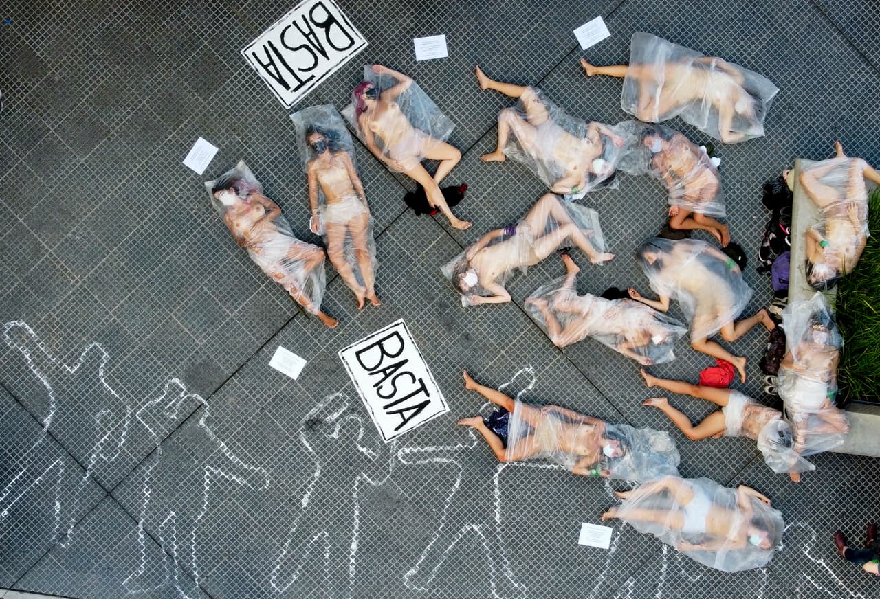 Mujeres manifestantes yacen en una acera cubiertas con bolsas de plástico en protesta contra la violencia de género, en Buenos Aires, Argentina, el miércoles 17 de febrero de 2021. Mujeres del movimiento "Ni Una Menos" marcharon para protestar contra lo que ellas llaman negligencia de los jueces a la hora de tomar medidas contra agresores de mujeres, una semana después del asesinato de Ursula Bahillo.