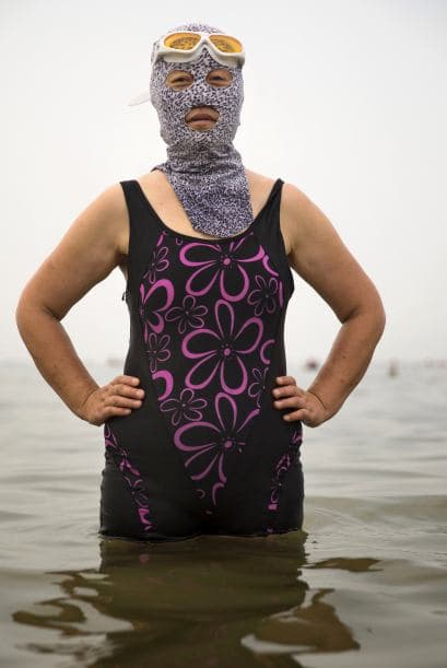 Una mujer china posa con un facekini en la playa Amarilla de Qingdao, China.