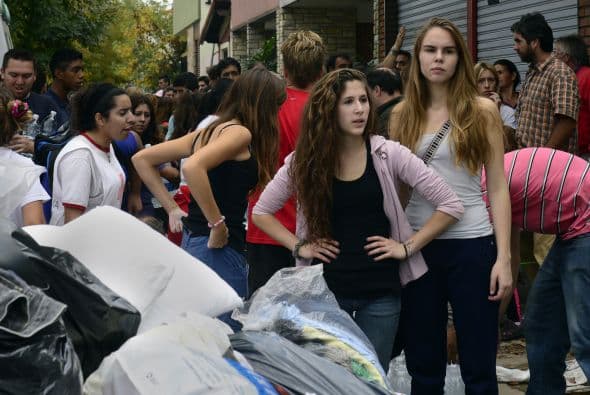 "Soy mensajero, compré tres bidones de agua mineral y los traje. Es lo que puedo", dice a la AFP Henry Rodríguez al parar su moto para entregar rápidamente su donación antes de seguir su recorrido laboral.
