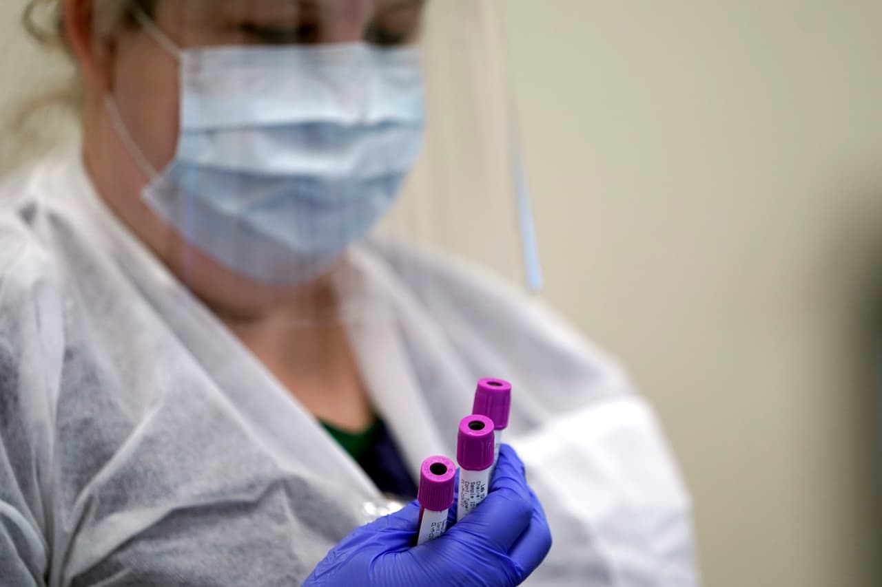 Una técnica de laboratorio médico sostiene muestras de sangre de pruebas de anticuerpos de covid-19 en Houston, Texas.
