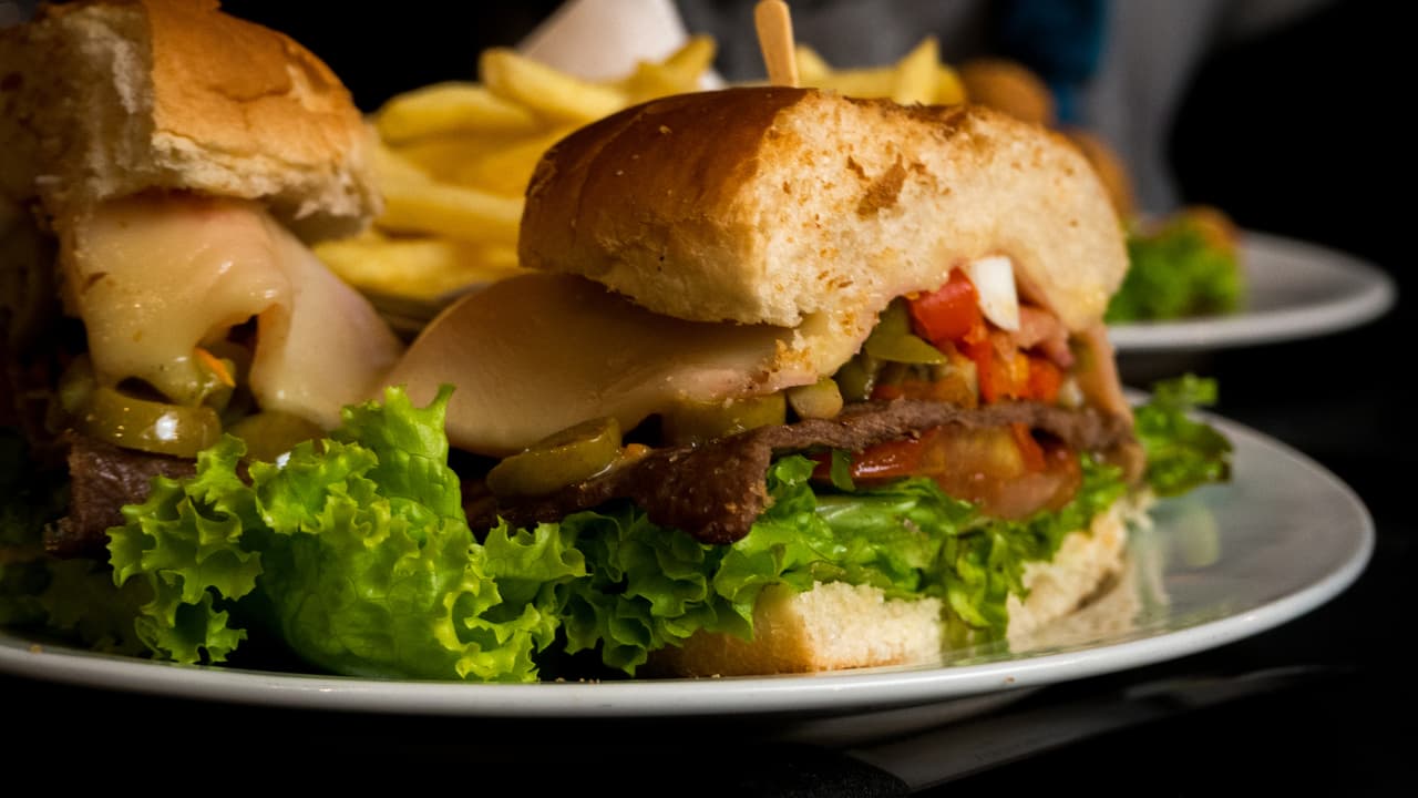 <b>Puesto 16. Chivito</b>
<br>
<br>Este sándwich es el plato nacional de Uruguay. Chivo es otra forma de decir cordero o cabra y según una leyenda el bocadillo se originó en la década de 1940. Supuestamente, a un chef se le pidió que preparara una cabra asada, pero como no tenía una, hizo un sándwich con trozos de casi todo lo que tenía en la cocina.
<br>
<br>El sándwich está relleno de churrasco (carne de res a la parrilla en rodajas finas), jamón, tocino, tomates, lechuga, mozzarella derretida y huevos fritos. Los panes para este sándwich deben grandes, como los ciabatta.
<br>