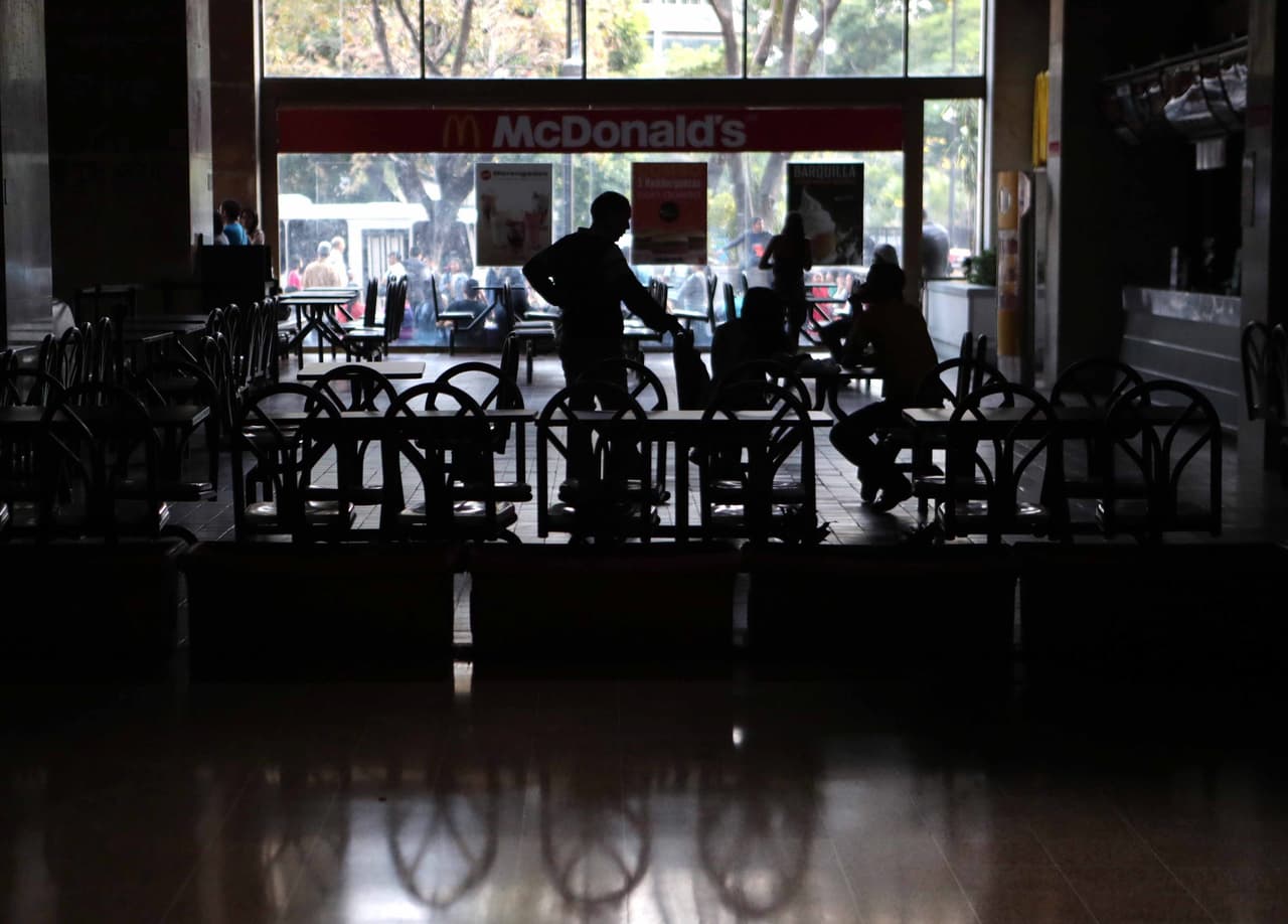 El apagón obligó a suspender la jornada laboral y las actividades escolares este viernes. Gran parte del país amaneció sin energía eléctrica por un problema que este viernes persiste en la principal generadora, la planta hidroeléctrica de Guri, al ubicada al sur del país. En la fotografía, un grupo de personas permanece a oscuras en un local comercial de Caracas, este viernes por la mañana.