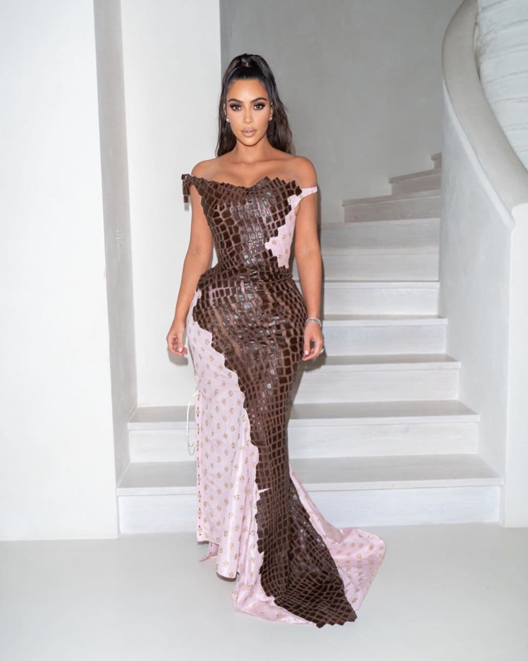 Kim optó por un vestido rosa con hombros descubiertos y piel de cocodrilo en color marrón. En esta imagen, se ve con mayor detalle el glamoroso look vintage que perteneció a la colección del verano 2000, según
<a href="https://www.eonline.com/news/1105830/kim-kardashian-and-her-kids-close-out-2019-with-their-most-glamorous-looks-yet" target="_blank">E!</a>
