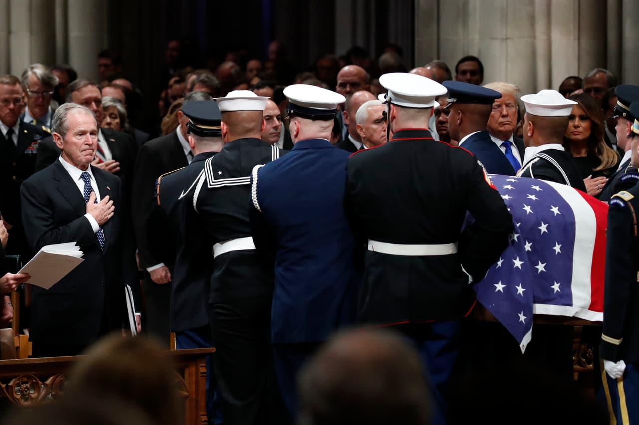 El expresidente George W. Bush lleva su mano derecha a su corazón durante la salida del féretro de su padre de la Catedral Nacional.