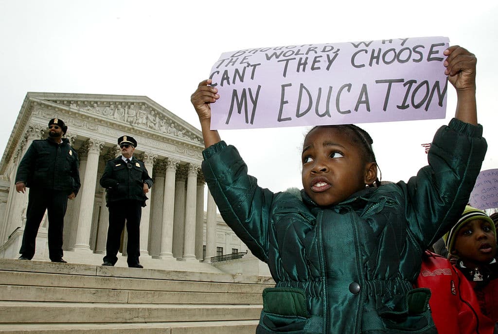 Brianna Slater, de 5 años, de Richmond, Virginia sostiene una pancarta en apoyo a los vouchers escolares frente a la Corte Suprema el 20 de febrero de 2002 en Washington, DC. La Corte Suprema, en un veredicto 5-4, mantuvo en pie el programa de vouchers escolares de Cleveland, Ohio, en junio de 2002.