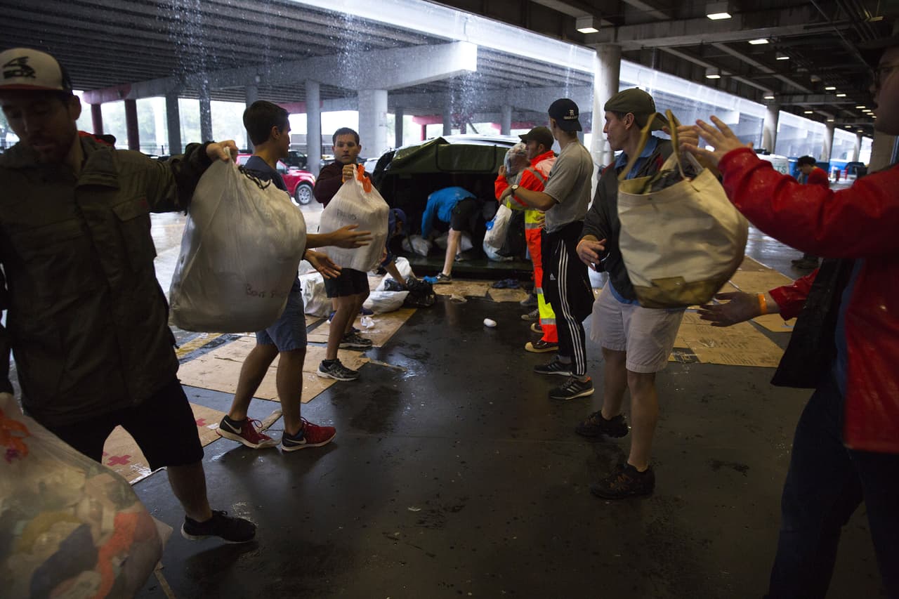 Voluntarios descargan insumos en el centro de convenciones George Brown de Houston.