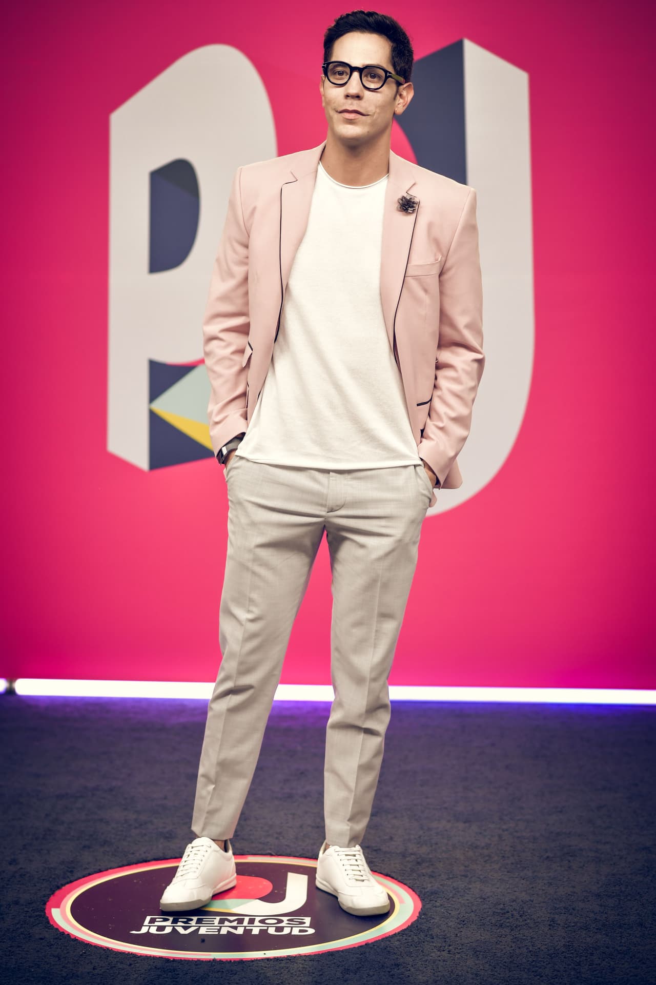 Christian Chávez sorprendió con su pulcro estilo para Premios Juventud. El actor combinó un pantalón beige con una playera blanca y un saco rosado de Galo Bertin, un diseñador mexicano de Querétaro.
