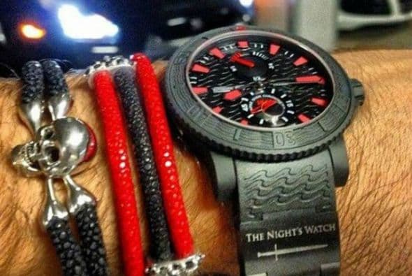 A esta imagen además de un reloj de lujo muestra costosos autos de fondo.