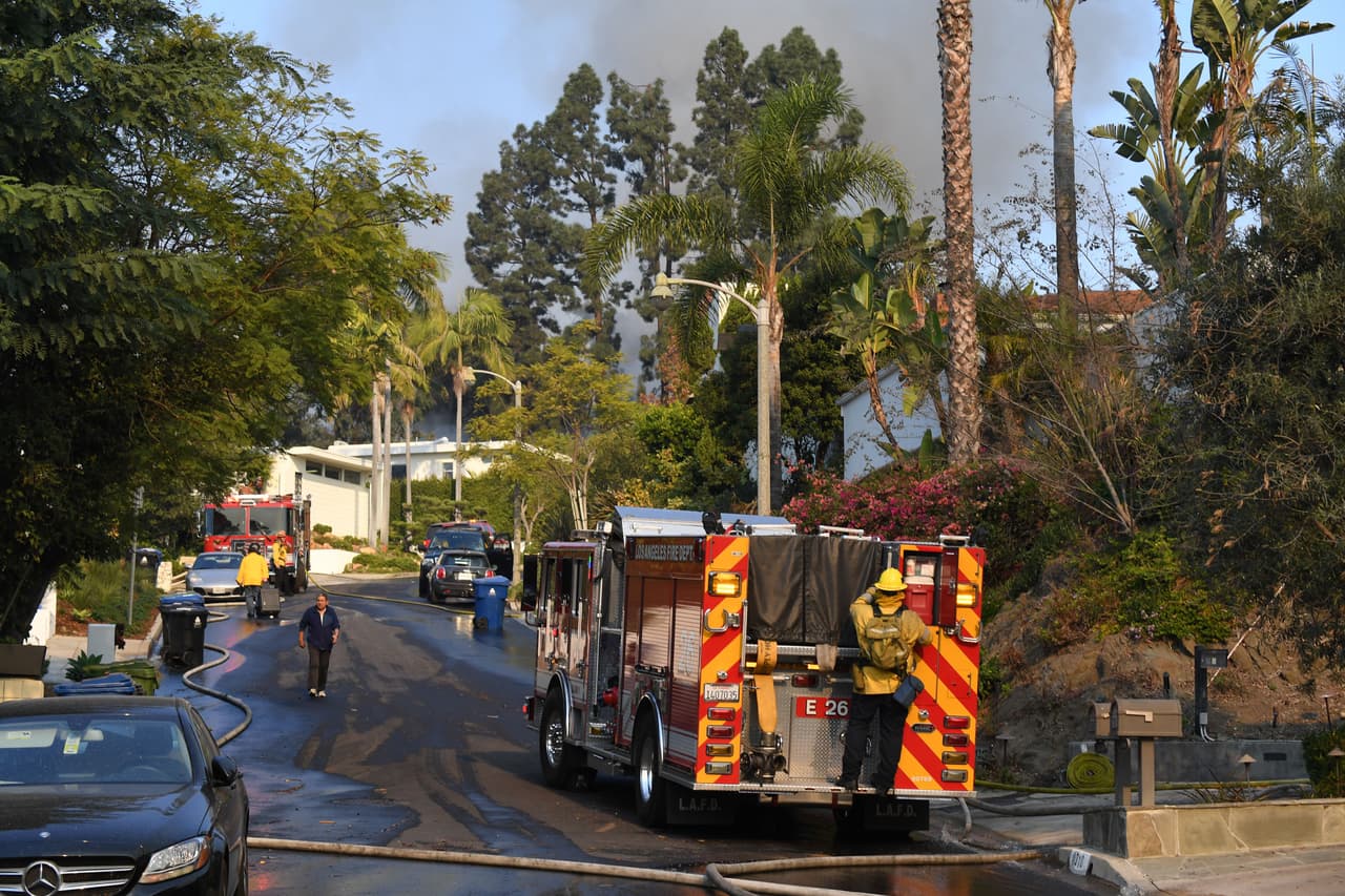 Los bomberos de los Ángeles intentan proteger del fuego a las casas de Bel-Air.