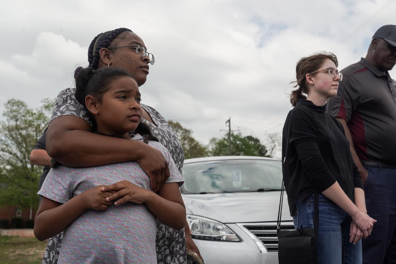 Adriana Pearson y su hija, Skyla Garcia, participan en una oración frente al sitio donde ocurrió el tiroteo en Dadeville, Alabama.