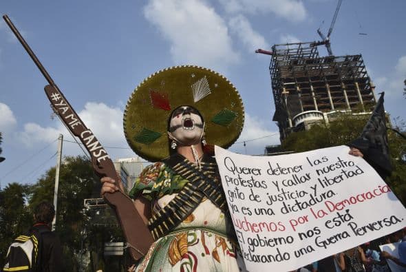 Una de las manifestantes vestida acorde con la época de la Revolución, porta una pancarta.