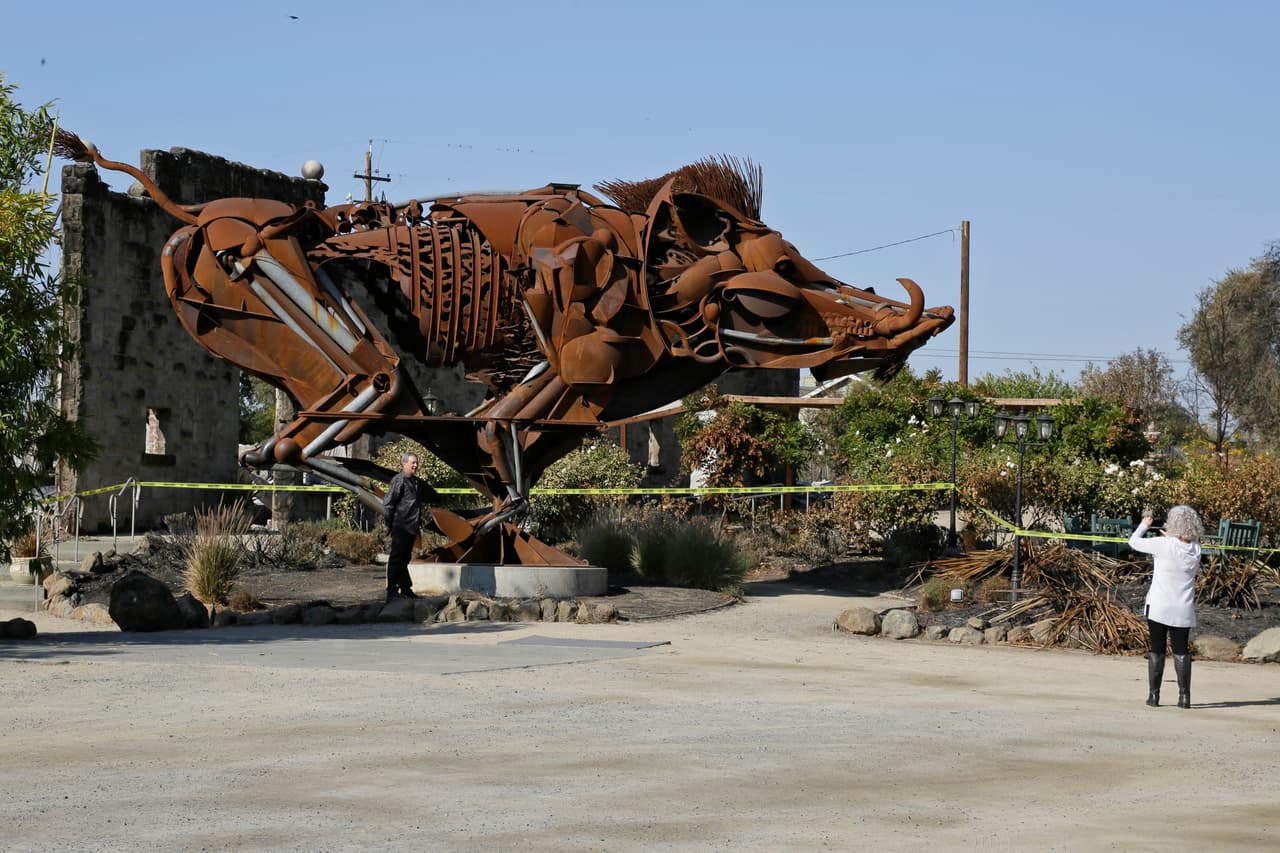 Paul Witt and y su esposa Cindy, turistas de Forney, Texas, se toman una foto frente al famoso toro metálico que le daba la bienvenida a los visitantes que llegaban a degustar los vinos de Soda Rock Winery.