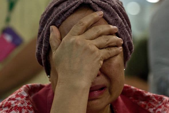 Familiares de los pasajeros del Malaysia Airlines vuelo MH17 lloran ante la tragedia.