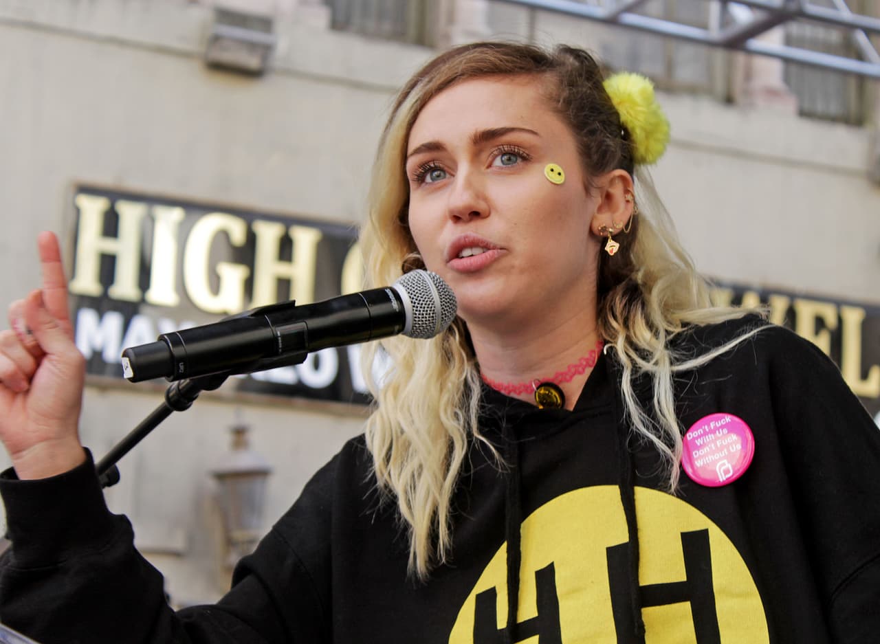 Miley dando un discurso sensible en el escenario del centro de Los Angeles.