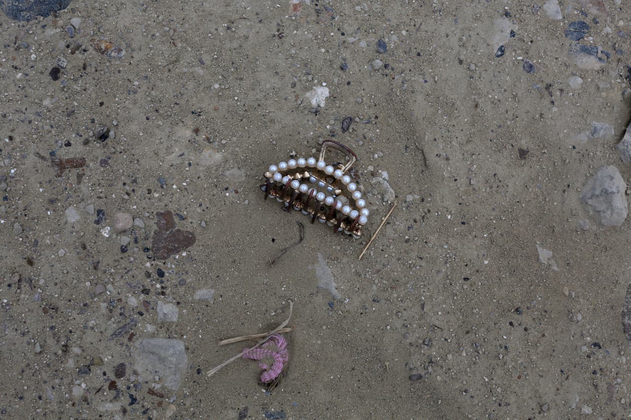 Un broche para el cabello yace entre los objetos que registran el paso de inmigrantes sin papeles en la frontera sur de EEUU, en Roma (Texas). Muchos de ellos,
<b>desesperados y asustados, salen de las balsas y esperan que los <i>coyotes </i>(traficantes de personas) les den indicaciones</b>. En promedio,
<a href="https://www.univision.com/noticias/inmigracion/embarazada-inmigrante-indocumentada-cruza-frontera-roma-texas" target="_blank">según declaraciones de las autoridades a Univision Noticias</a>, cada noche pasan entre 150 y 200 personas en esta zona.