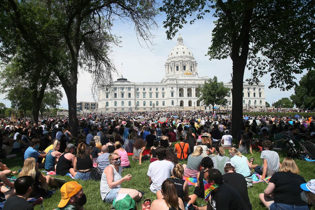 Miles de manifestantes se reúnen pacificamente -algunos sentados en el suelo- en el Capitolio del Estado en St. Paul, Minnesota, en la tarde del martes.