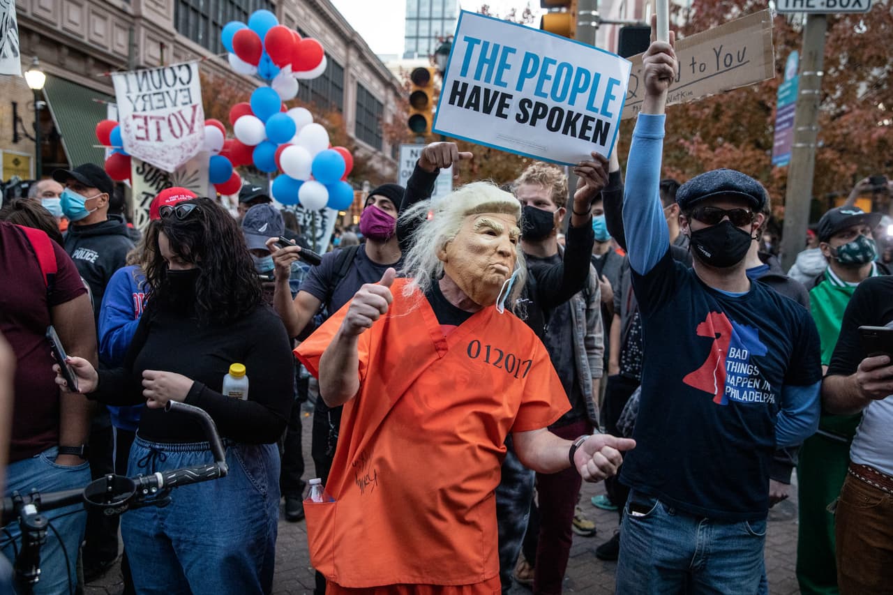 Una persona vestida como Donald Trump en un mono de prisión baila frente a los partidarios del presidente en Centro de Convenciones de Pensilvania donde se sigue el conteo de votos.
