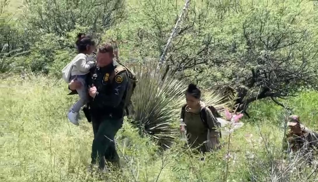 Un agente de la Patrulla Fronteriza carga a una niña de 4 años que cruzó con su madre, en este grupo venían 6 inmigrantes y se encontraba por Sasabe, que se ha convertido en la puerta de acceso de Arizona.