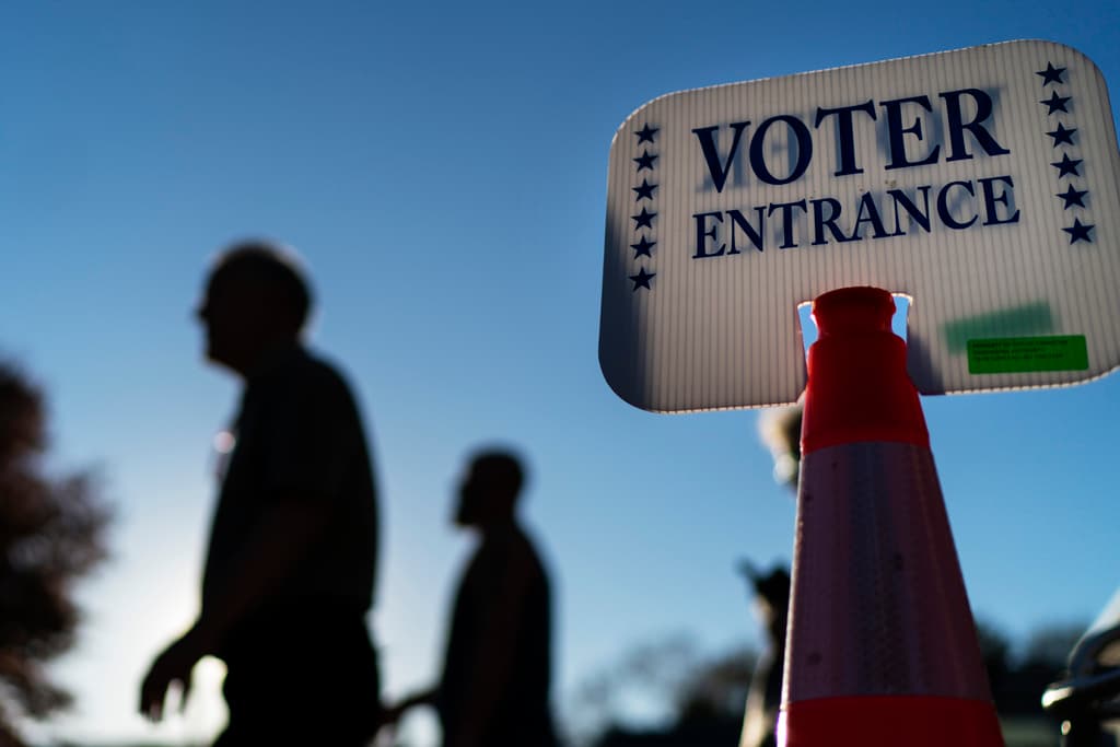 FILE - Voters pass a sign outside a polling site in Warwick, R.I., on Nov. 7, 2022, after casting their ballots on the last day of early voting before the midterm election. A crowded field of candidates will be on the ballot in Rhode Island on Tuesday with an eye on replacing former U.S. Rep. David Cicilline, the seven-term Democrat who resigned in May to run a nonprofit foundation. (AP Photo/David Goldman, File)