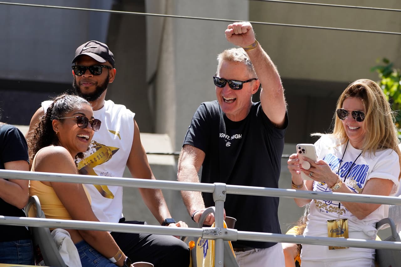 El entrenador en jefe de los Golden State Warriors, Steve Kerr, levanta el puño mientras cabalga en el desfile del campeonato de la NBA en San Francisco, el lunes 20 de junio de 2022. (Foto AP/Eric Risberg)