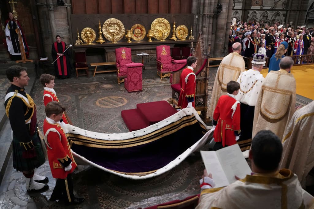En esta imagen se ve a los pages reales sujetando la túnica carmesí durante la coronación de Carlos III en la Abadía de Westminster.