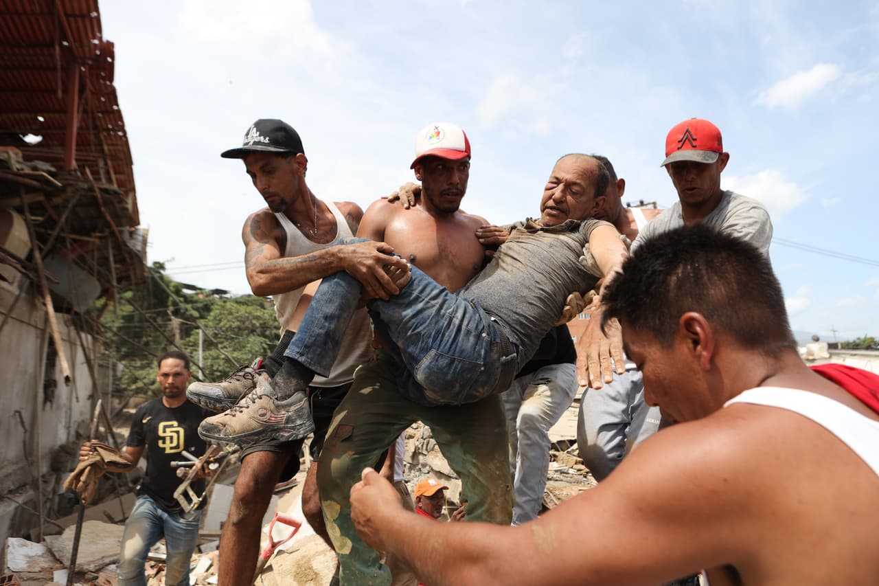 Vecinos transportan a un hombre rescatado de entre los escombros de un edificio derrumbado un día después de que los terremotos azotaran La Guaira, Venezuela, el jueves 25 de junio de 2026.